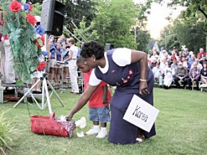 Mother and child lay a flower in honor of fallen soldiers.